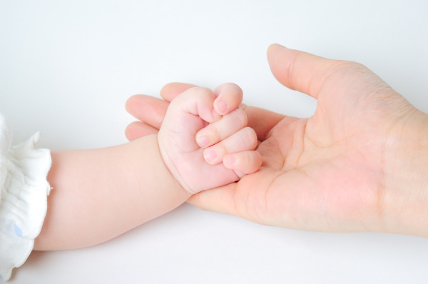 Hand der Mutter hält Hand des Babys (Foto: Decellio)