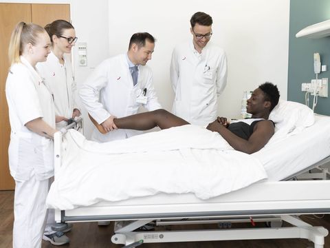 Orthopäden am Bett eines Patienten im Spandauer Krankenhaus