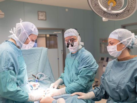 zwei Chirurgen und eine operationstechnische Assistentin während einer OP