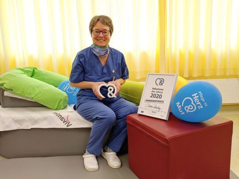 Pflege im Krankenhaus in Berlin-Schöneberg: Claudia Rheinbay, Hebamme des Jahres 2020, posiert sitzend mit ihrem Preis.