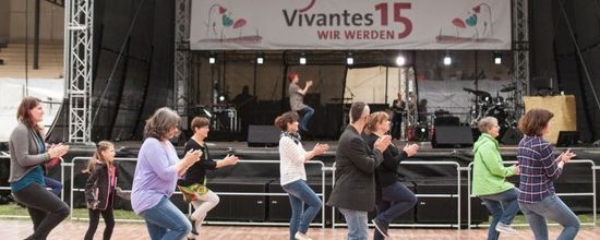 Line Dance im Wenckebach-Klinikum in Berlin-Tempelhof: Das Bild zeigt die Line-Dance-Gruppe draußen vor einer Bühne beim Tanzen anlässlich des 15. Geburtstags von Vivantes.