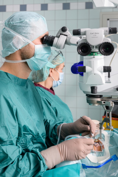 Arzt in OP-Kleidung entfernt mithilfe eines BIOM für eine universelle Sicht den Glaskörper aus dem Auge